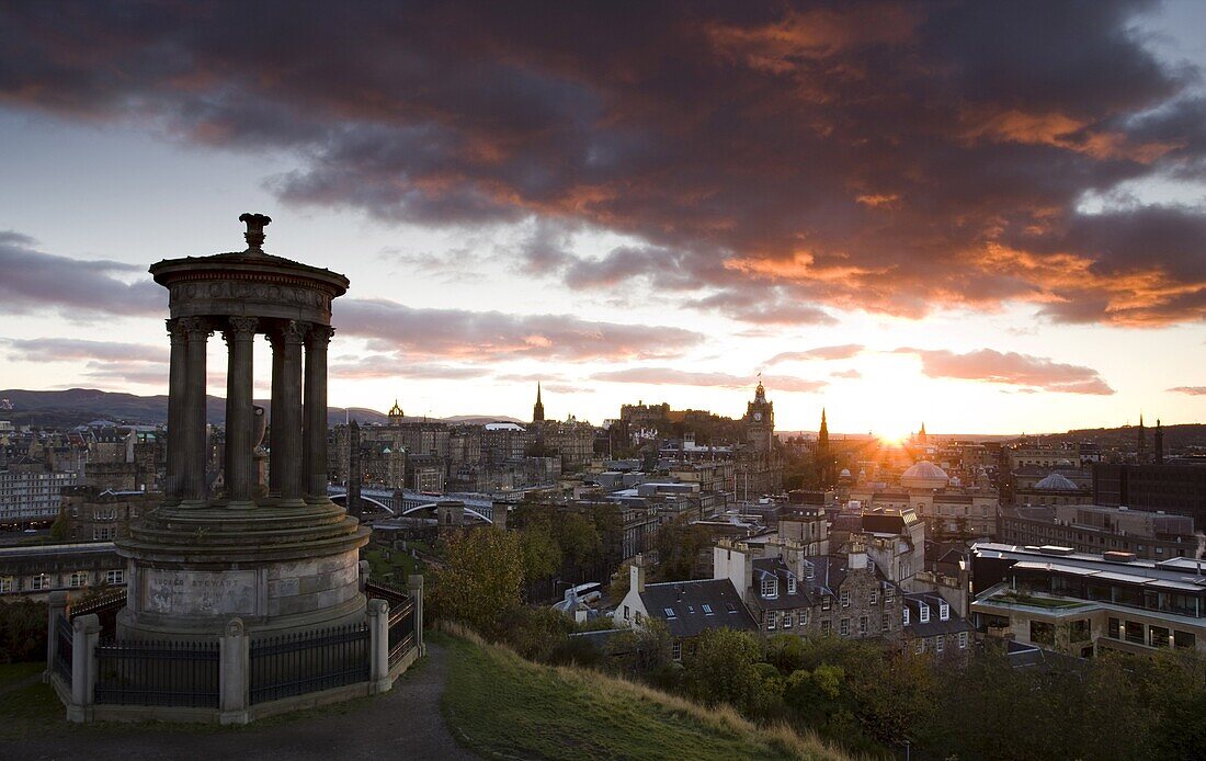 View over Edinburgh from Calton Hill at sunset with the Dugald Stewart Monument in the foreground, Edinburgh, Lothian, Scotland, United Kingdom, Europe