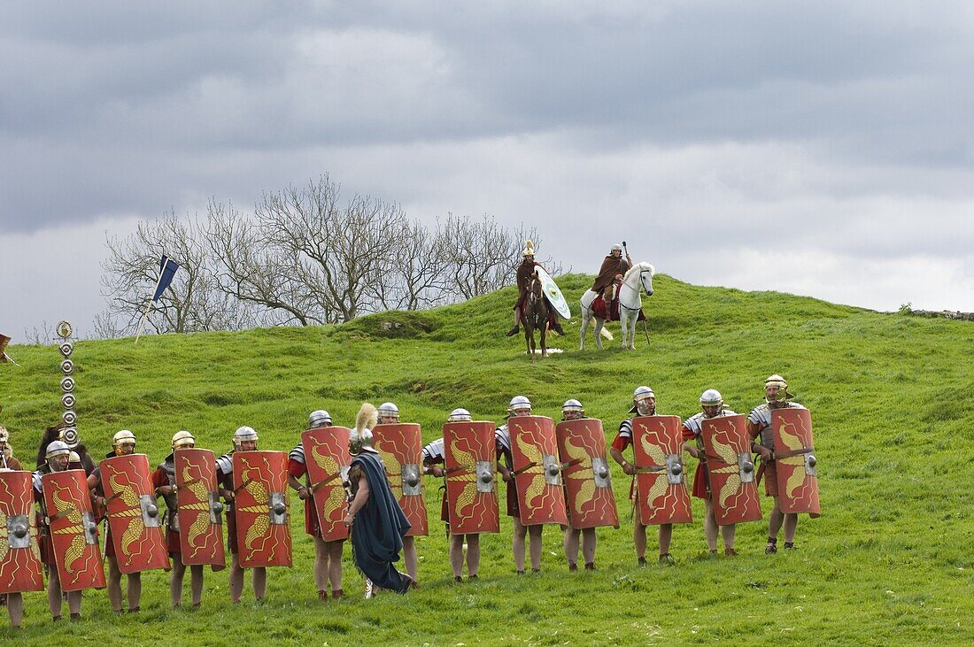 Roman soldiers of Ermine Street Guard, in line abreast with shields and stabbing swords, cavalry in support, Birdoswald Roman Fort, Hadrians Wall, Northumbria, England, United Kingdom, Europe