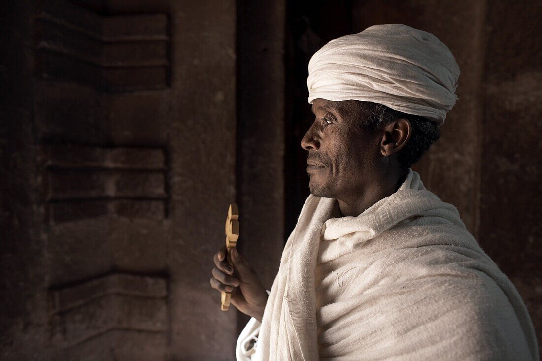 A priest stands at the entrance to the rock-hewn church of Bet Amanuel, in Lalibela, Ethiopia, Africa