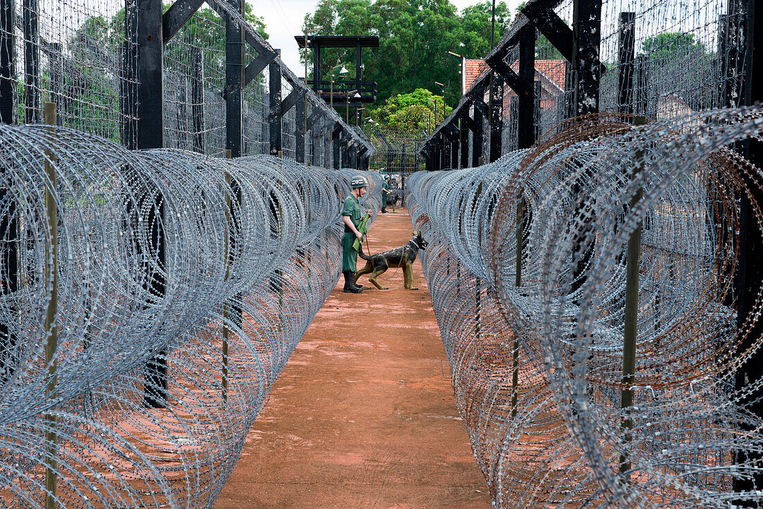 Barbed wire and figure of guard with watchdog in former prison and now museum, Phu Quoc, Mekong Delta, Vietnam, Asia