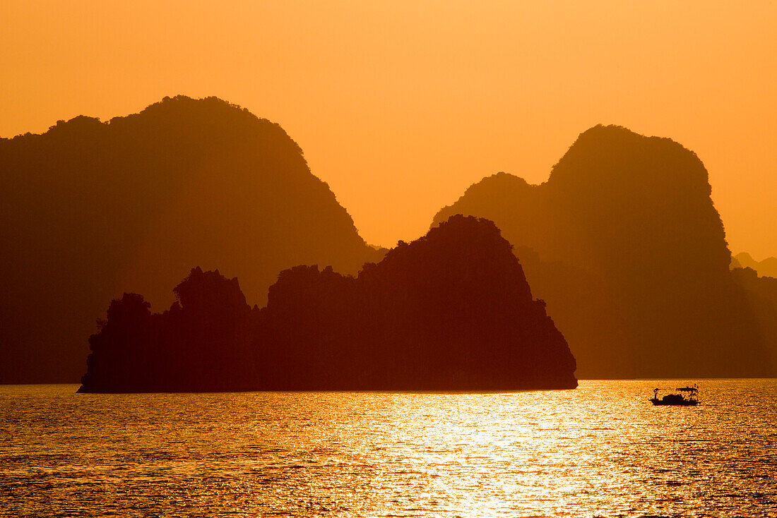 Fishing boat, Ha Long Bay islands and mountains at sunset, Ha Long Bay, Quang Ninh Province, Vietnam, Asia