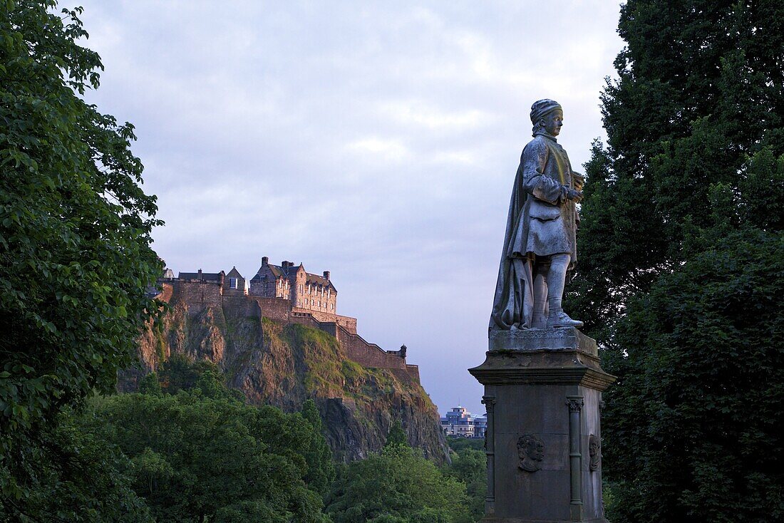 Statue of Allan Ramsay, with Edinburgh Castle at sunset from West Princes Street Gardens, Edinburgh, Scotland, United Kingdom, Europe