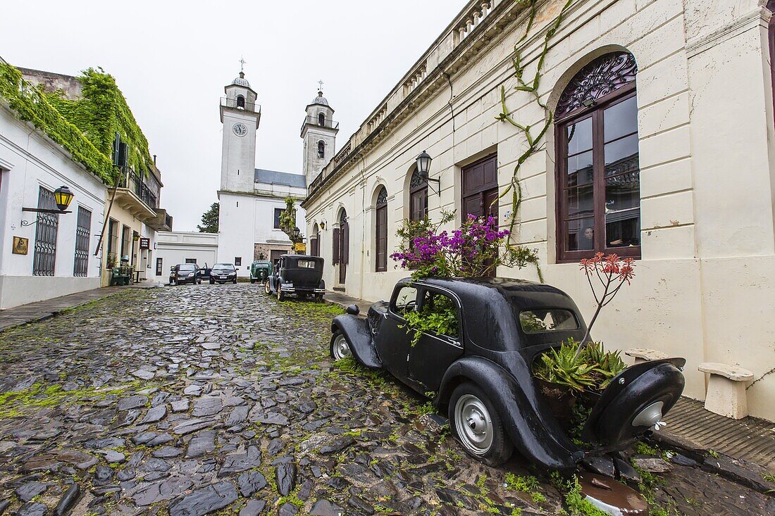 Old car turned into planter on cobblestone street in Colonia del Sacramento, Uruguay, South America