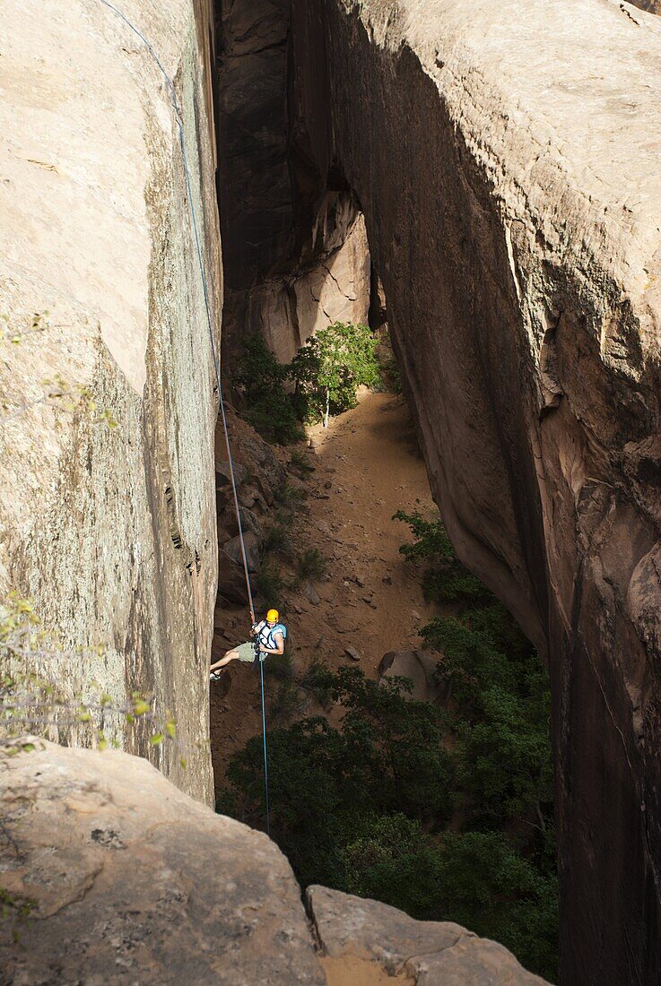 Tourist hanging on a rope while Canyoning in the area of the Slickrock Trail, near Arches National Park, Moab, Utah, United States of America, North America