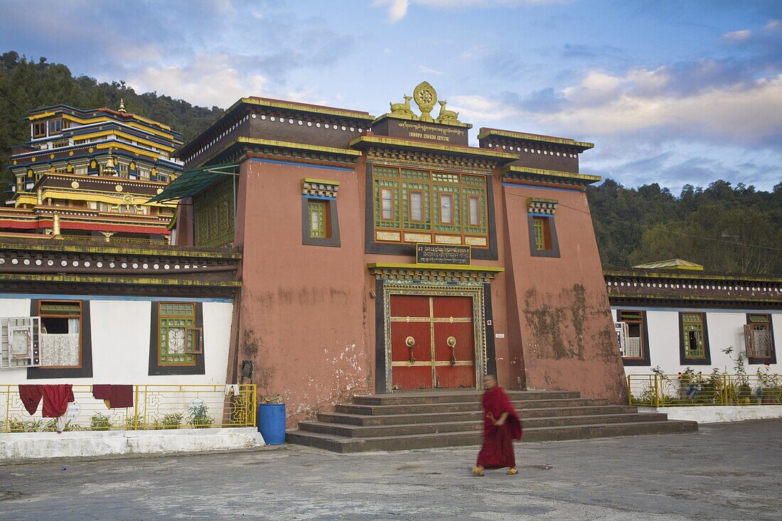Monk walking past entrance to main monastery building, Rumtek Gompa Complex, Gangtok, Sikkim, India, Asia