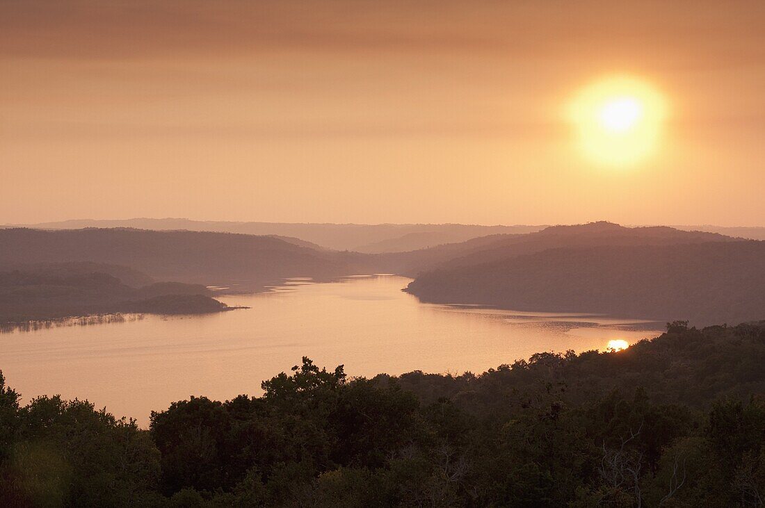 View of sunset over Lake Yaxha from Temple 216, Yaxha, Guatemala, Central America