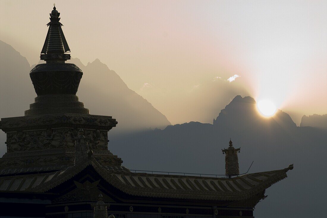 Buddhist temple at dawn with mountains beyond, Snow mountain, Tagong Grasslands, Sichuan, China, Asia