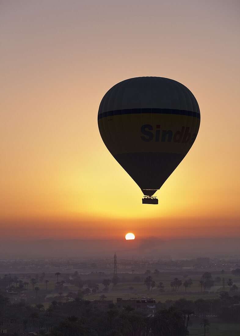 Hot air balloon at sunrise, floating over Luxor's Theban Necropolis, Thebes, Egypt, North Africa, Africa