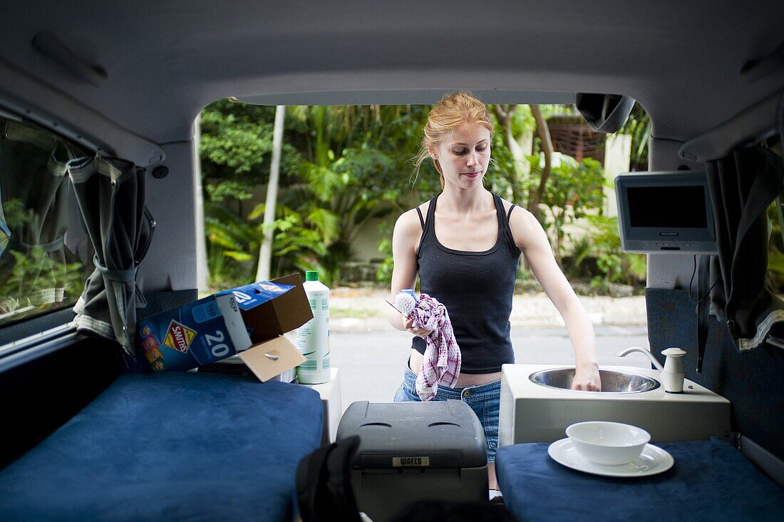 Woman washing up in a campervan, Byron Bay, New South Wales, Australia, Pacific