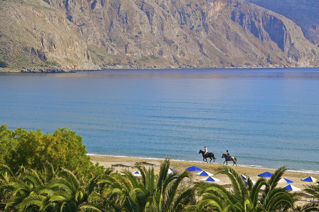 Two tourists riding horses on the beach, Giorgioupolis, Crete, Greek Islands, Greece, Europe