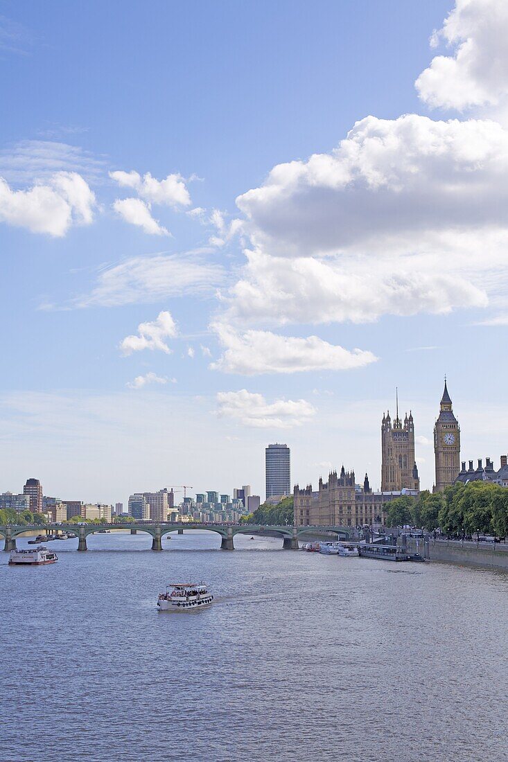 Tourist cruise boat on the River Thames and the Houses of Parliament in the distance, London, England, United Kingdom, Europe