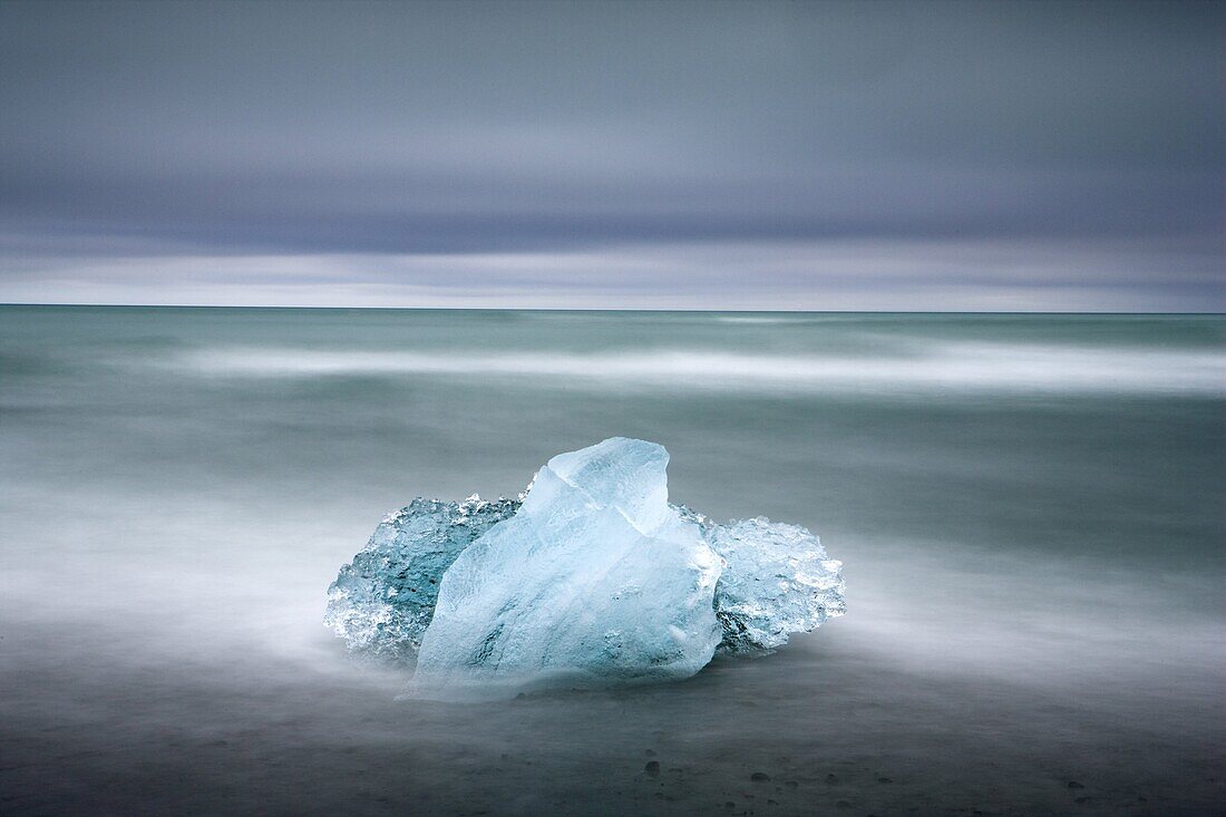 Piece of glacial ice washed ashore by the incoming tide near glacial lagoon at Jokulsarlon, Iceland, Polar Regions