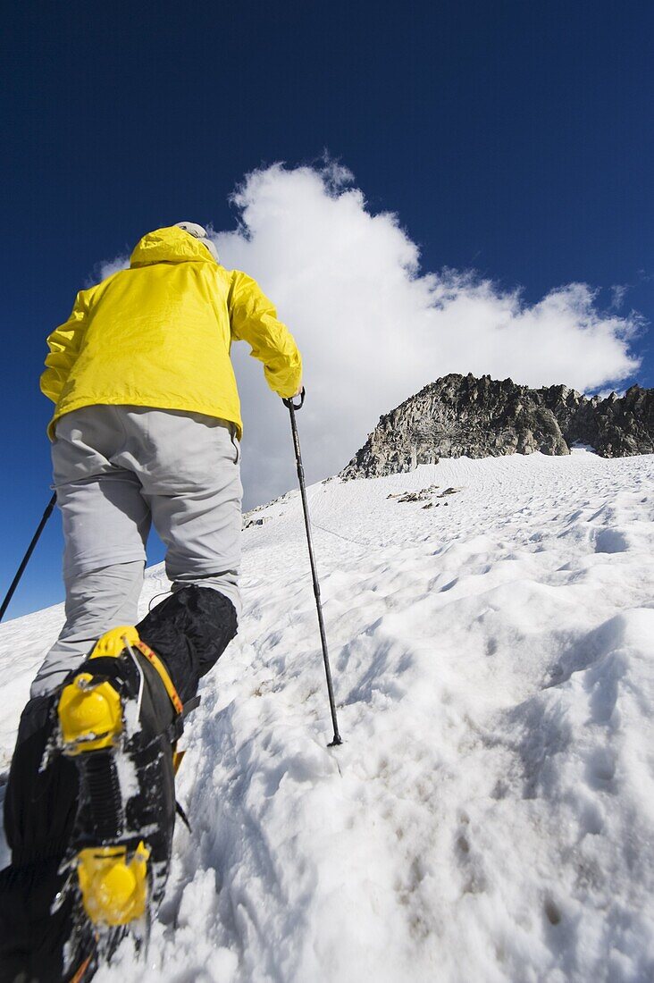 A climber walking up a snowfield, Pico de Aneto, the highest peak in the Pyrenees, Spain, Europe