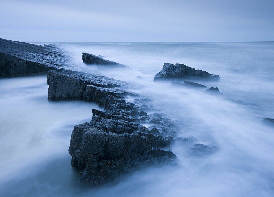 Swirling tide around jagged rocks on Spekes Mill Mouth beach, Hartland, Devon, England, United Kingdom, Europe