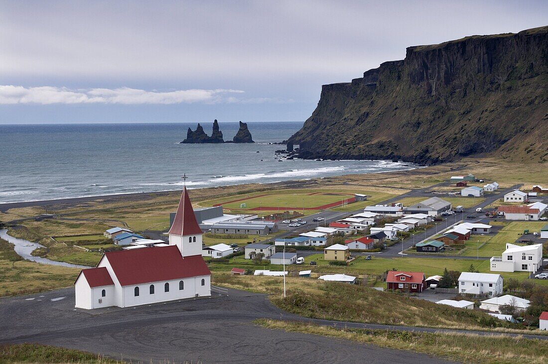 Church, village of Vik (Vik a Myrdal) and Reynisdrangar sea stacks in the distance, Iceland, Polar Regions