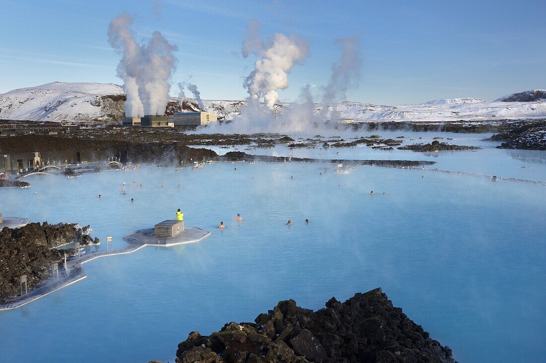 People relaxing in Blue Lagoon geothermal spa, Svartsengi Geothermal Power Station in the distance, Grindavik, Reykjanes Peninsula, Iceland, Polar Regions