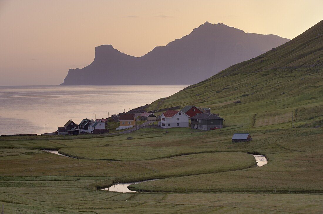 Houses at Elduvik at sunrise, with view across Funningsfjordur of Kalsoy cliffs of Nestindar, 788m, and Borgarin, 537m, Eysturoy, Faroe Islands (Faroes), Denmark, Europe