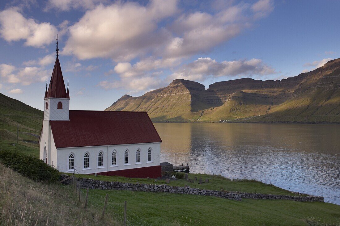 Church built in 1920 at Husar, Kalsoyarfjordur and Kunoy hills in the distance, Kalsoy, Nordoyar, Faroe Islands (Faroes), Denmark, Europe
