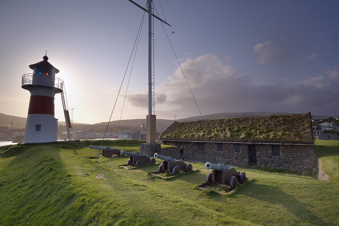 Skansin fort, old fort guarding Torshavn and its harbour (old brass cannons, WW2 british marine guns and lighthouse), Nolsoy in the distance, Torshavn, Streymoy, Faroe islands (Faroes), Denmark, Europe.