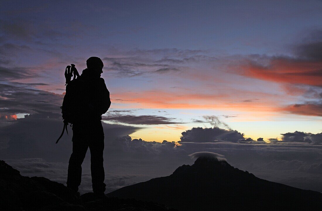 A climber looks towards Mawenzi from near the summit of Mount Kilimanjaro at dawn,  Tanzania,  East Africa,  Africa