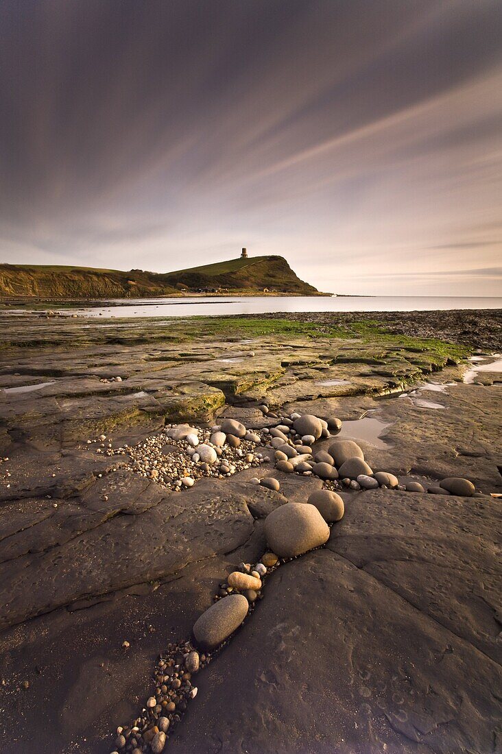 View across Kimmeridge Bay at dusk towards Hen Cliff and Clavell Tower, Perbeck District, Dorset, England, United Kingdom, Europe