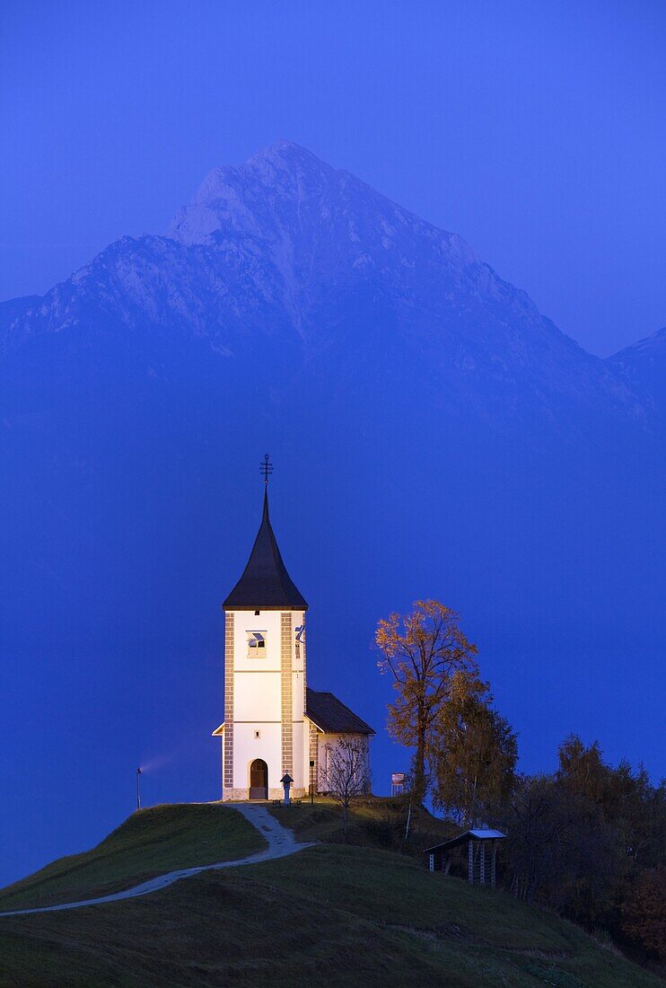 The floodlit church of St. Primoz at dusk near Jamnik, Gorenjska, Slovenia, Europe