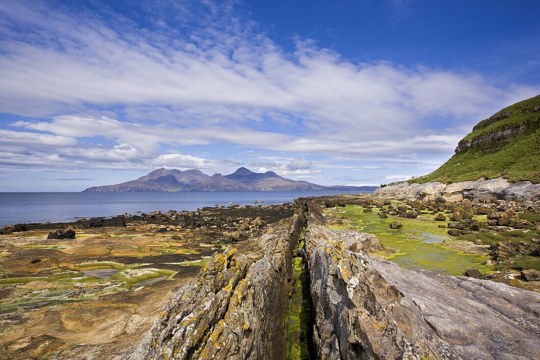 Basalt dyke on Eigg with the Isle of Rum in the distance, Isle of Eigg, Inner Hebrides, Scotland, United Kingdom, Europe