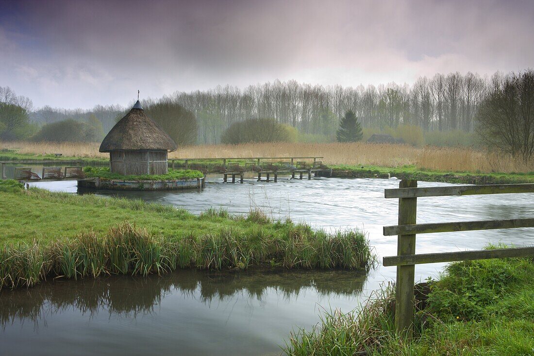 Thatched fisherman's hut and eel traps spanning the River Test near Leckford, Hampshire, England, United Kingdom, Europe