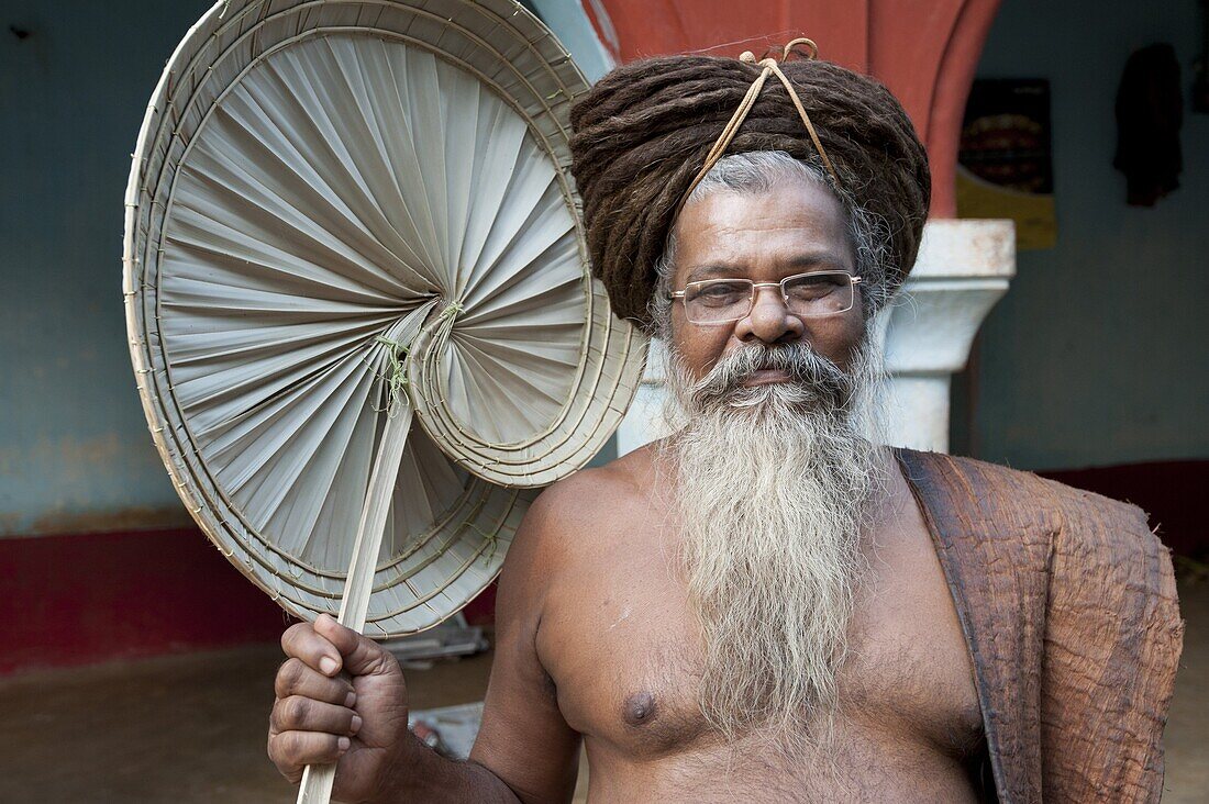 Joranda monk wearing tree bark cloth, holding palm leaf fan, with uncut hair piled up on top of his head, Joranda, Orissa, India, Asia