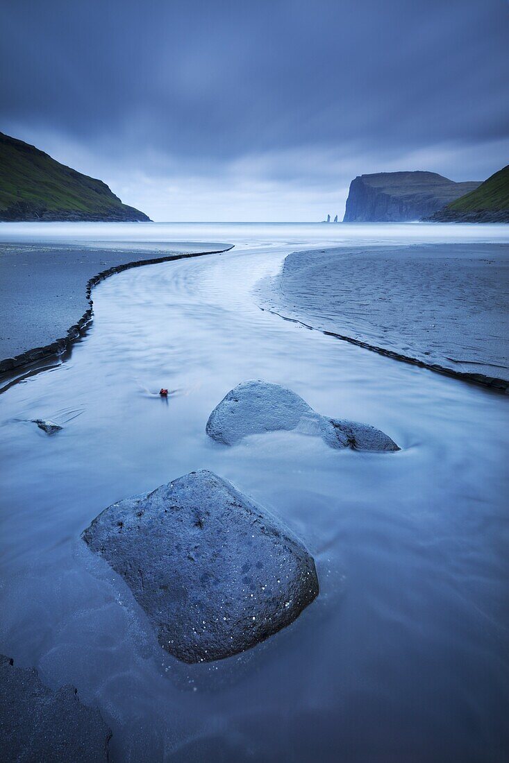 A stream runs into the sea at Tjornuvik on the island of Streymoy in the Faroe Islands, Denmark, Europe