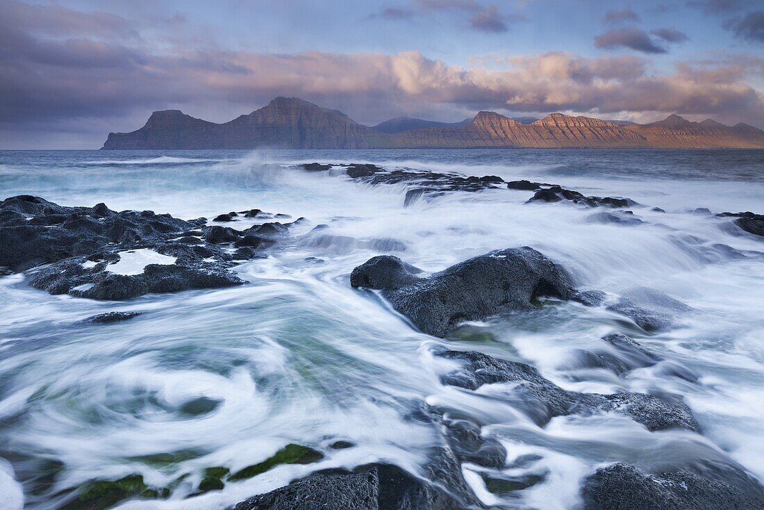 Surging waves break over the rocky shores at Gjogv on the island of Eysturoy, Faroe Islands, Denmark, Europe