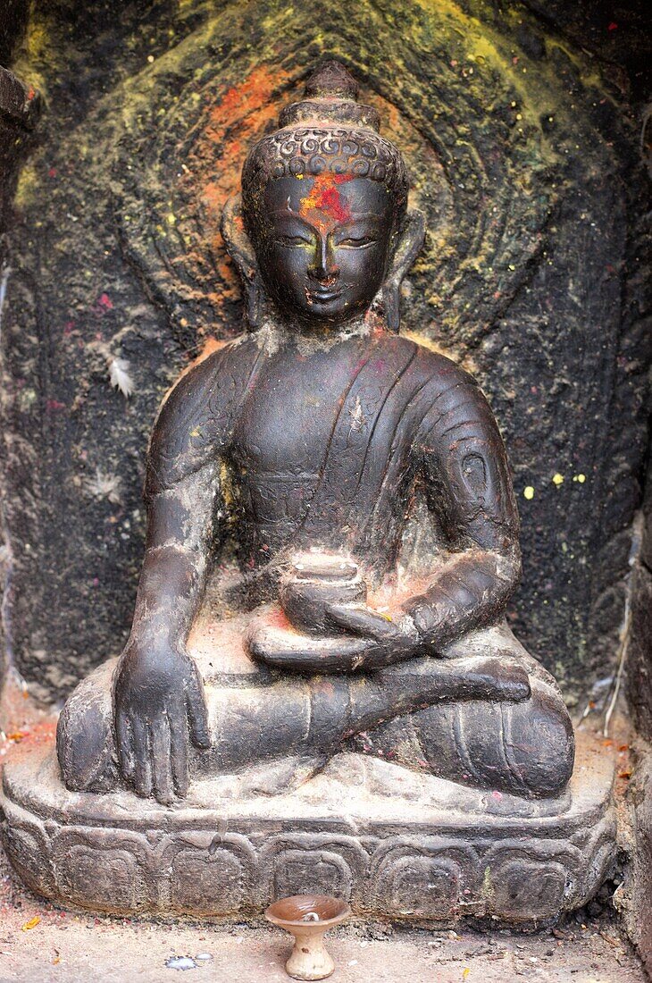 Small shrine with blessing of colourful paint and offerings of food, Swayambhunath (The Monkey Temple), Kathmandu, Nepal, Asia