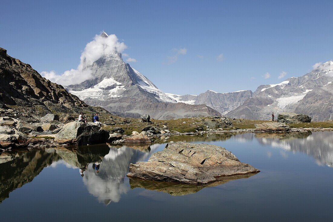 Hiker resting at Riffelsee and the Matterhorn behind, Zermatt, Valais, Swiss Alps, Switzerland, Europe