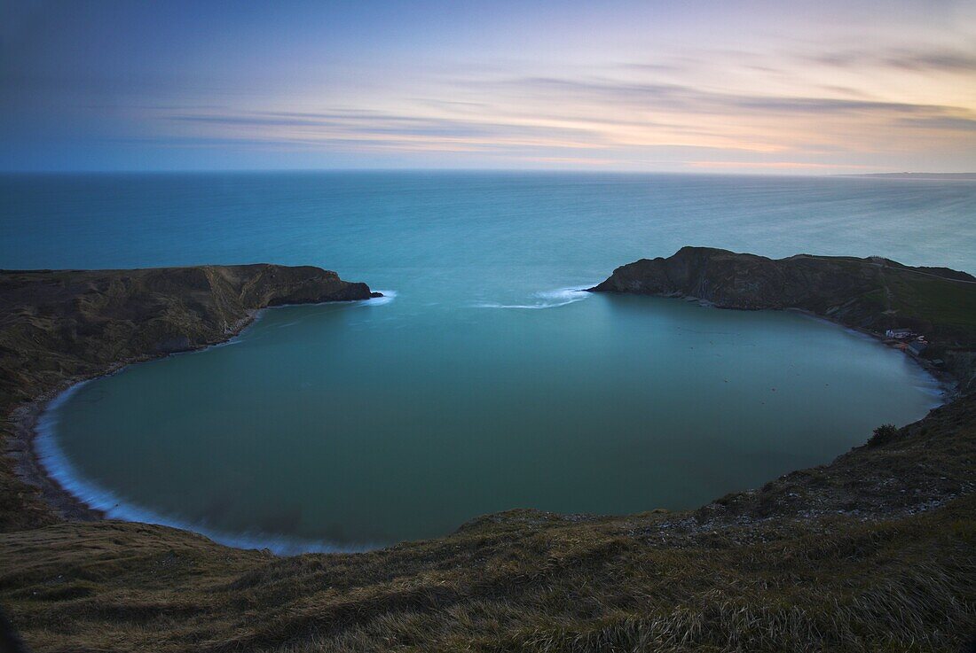 Twilight on the clifftops overlooking the circular Lulworth Cove, Jurassic Coast, UNESCO World Heritage Site, Dorset, England, United Kingdom, Europe