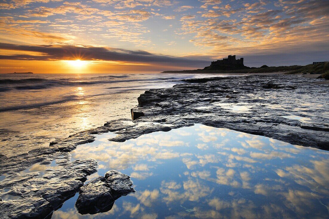 Spectacular sunrise on the coast near Bamburgh Castle, Northumberland, England, United Kingdom, Europe