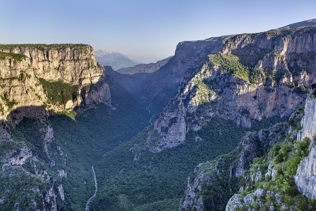 Early morning sun starts to light up the Vikos Gorge and Voidomatis River, from the Beloi viewpoint in Zagoria, Epirus, Greece, Europe