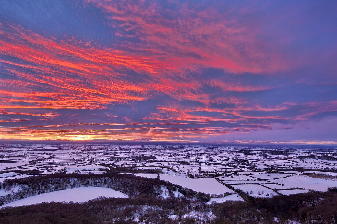 Fiery sunset over a snow covered Gormire Lake from Sutton Bank on the edge of the North Yorkshire Moors, Yorkshire, England, United Kingdom, Europe