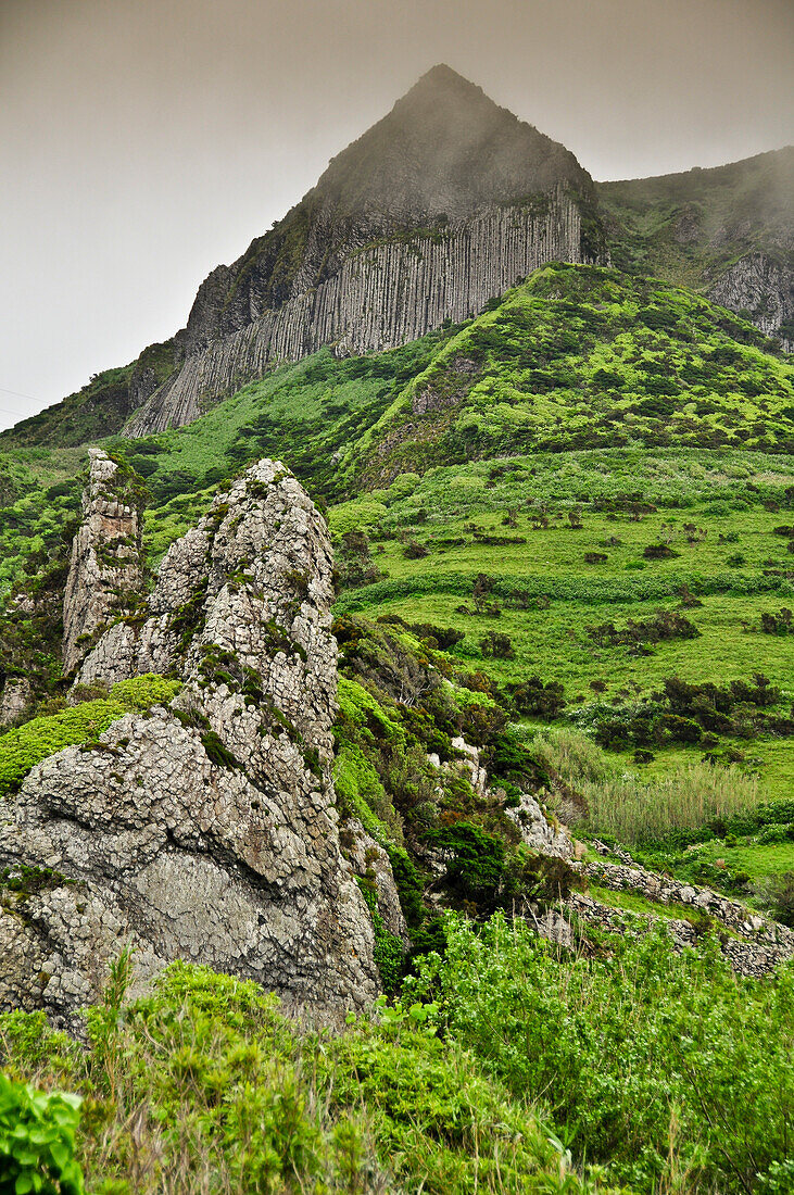 Volcanic basalt mountain Rocha dos Bordoes in the foggy highlands, Island of Flores, Azores, Portugal, Europe, Atlantic Ocean