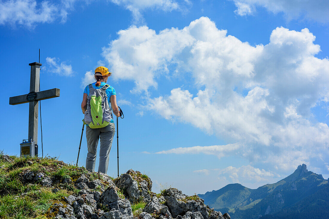 Frau beim Wandern steht auf Gipfel und schaut zur Kampenwand, Zellerwand, Chiemgauer Alpen, Oberbayern, Bayern, Deutschland