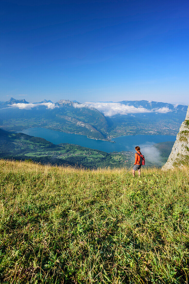 Frau beim Wandern blickt auf Lac d'Annecy, La Tournette, Hochsavoyen, Frankreich