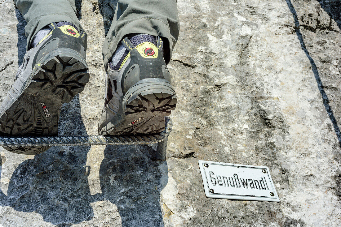 Person standing on step tread, next to sign Genusswandl, Hochthronklettersteig, fixed rope route Hochthron, Untersberg, Berchtesgadener Hochthron, Berchtesgaden Alps, Upper Bavaria, Bavaria, Germany