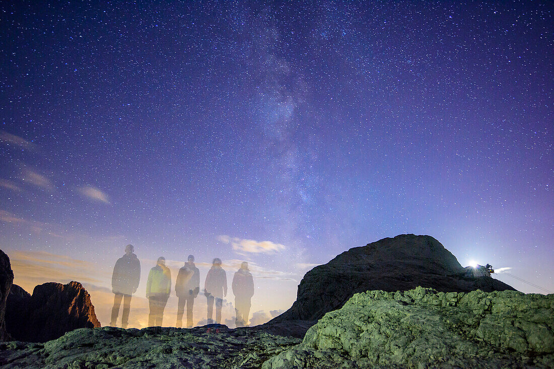 Several persons standing beneath stary sky with milky way, Rosetta in background, Pala range, Dolomites, UNESCO World Heritage Dolomites, Trentino, Italy