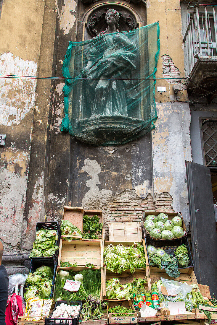 Gemüsestand, alte Mauer, Gemäuer, bröckelnder Putz, grünes Schutznetz, Heiligenstatue, Markt in der Altstadt, Neapel, Napoli, Italien