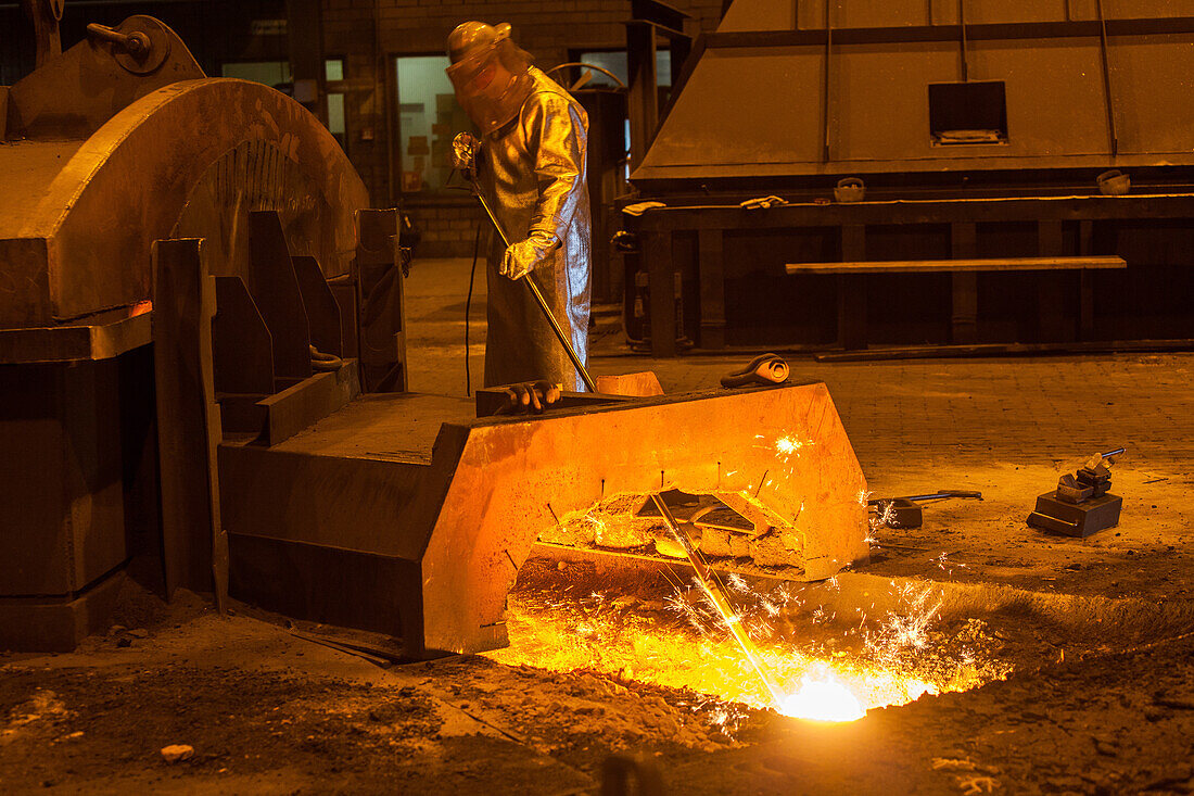 Salzgitter AG, Stahlwerk, Stahlhuette, Walzwerk, Hochofen, Stahlarbeiter in silbernem Schutzanzug, Funken, Glut, wie Lavastrom, Schlacke und Roheisen, Anstich, Industrie, Niedersachsen, Deutschland