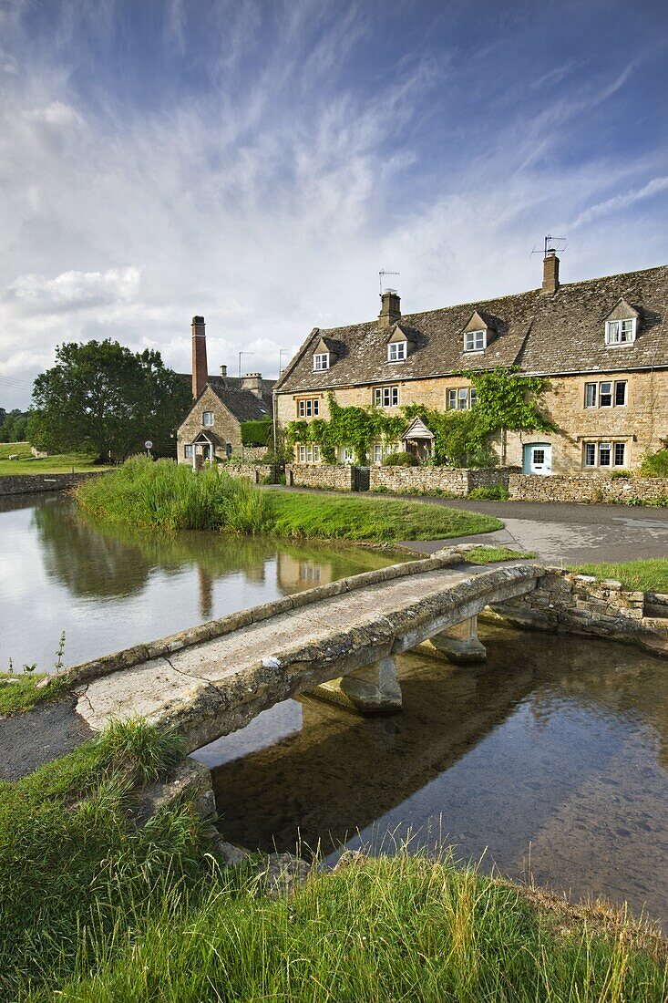 Stone footbridge and cottages at Lower Slaughter in the Cotswolds, Gloucestershire, England, United Kingdom, Europe