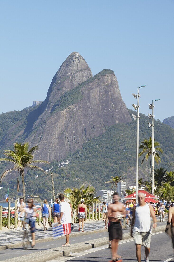 People cycling and walking along pedestrianised street on Sunday, Ipanema, Rio de Janeiro, Brazil, South America