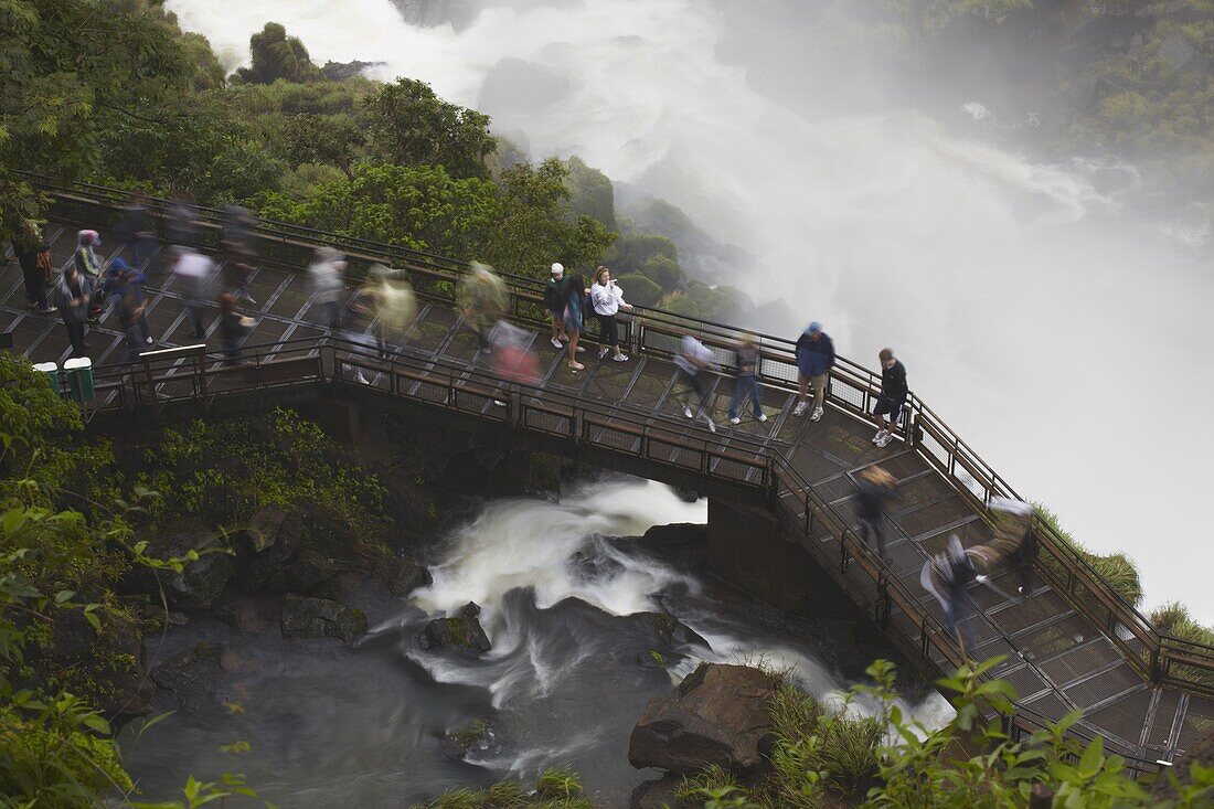 Tourists crossing bridge at foot of Bossetti Falls, Iguazu Falls, Iguazu National Park, UNESCO World Heritage Site, Misiones, Argentina, South America