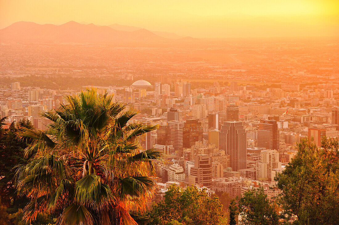 'Sonnenuntergang über Skyline der Hauptstadt Santiago de Chile mit Anden vom Aussichtberg Cerro San Cristobal, Stadtteil Bellavista, Región Metropolitana, Chile, Südamerika;'
