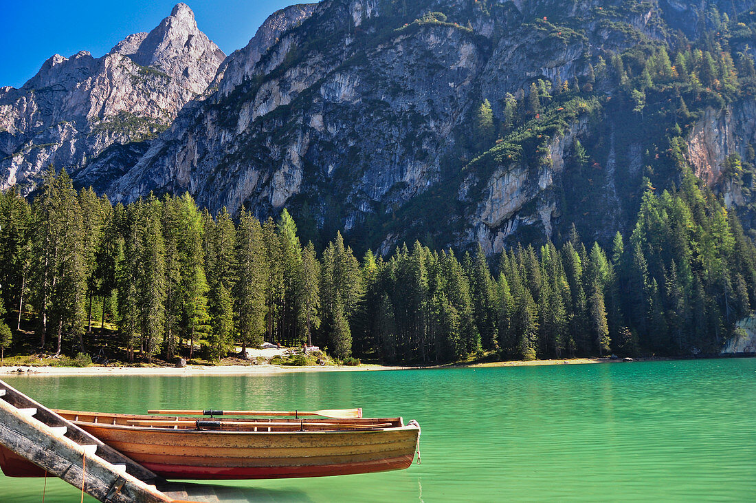 Lake Lago di Braies (Pragser Wildsee) with jetty and rowing boat beneath mountain Seekofel in autumn, Nature Park Fanes-Sennes-Braies, Val Pusteria Valley, Sesto, Dolomites, South Tyrol, Veneto, Alto Adige, UNESCO world heritage side, Italy, European Alps
