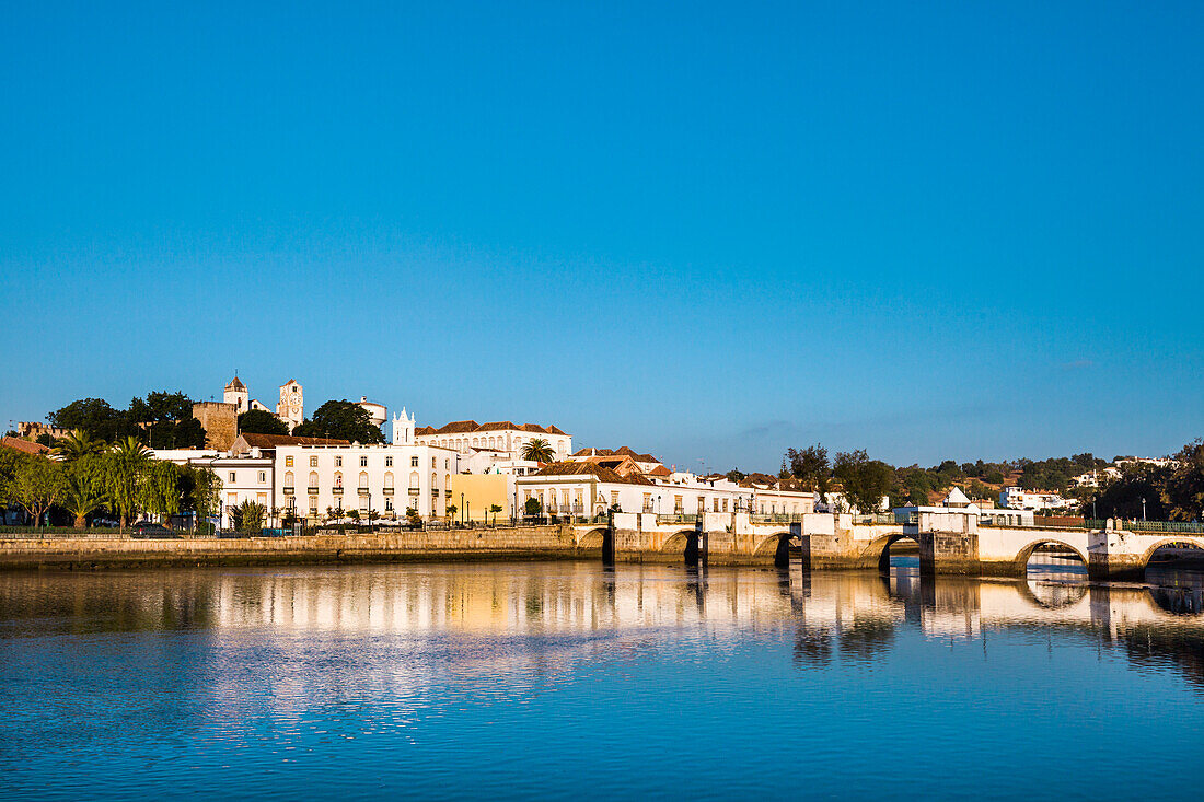 Blick über Rio Gilao auf die Stadt mit römischer Brücke, Tavira, Algarve, Portugal